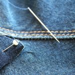 Зафиксированная шпильками заплатка на джинсах перед пришиванием вручную